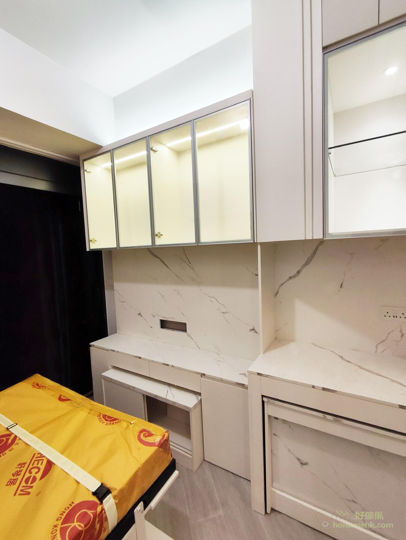 电视柜的玻璃门设计，让住户可以展示收藏品或常用物品，配合内置灯光，增添家居的高级感。下层则提供实用的收纳空间，让杂物有序归位，保持整体美观。