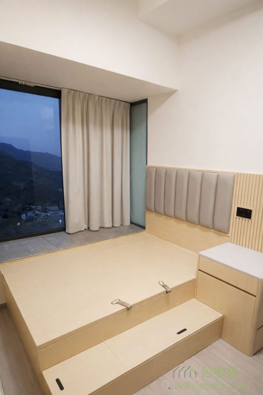 另一間房則以地台床為主，配合儲物抽屜和床頭板，既保持簡潔又提升實用性。整體木紋色調營造出溫暖的居家氛圍，令人放鬆身心。