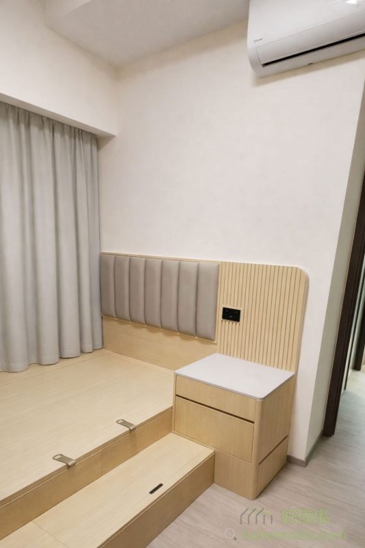 另一間房則以地台床為主，配合儲物抽屜和床頭板，既保持簡潔又提升實用性。整體木紋色調營造出溫暖的居家氛圍，令人放鬆身心。