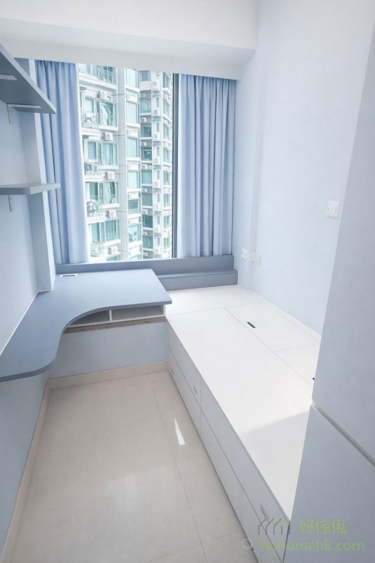 在細房內，L形書枱的設計充分善用了窗台空間，為日常學習和工作提供了方便的工作區域。枱面採用懸空設計，避免了傳統書枱的笨重感，並為電腦椅的移動提供了更多靈活性。這種設計不僅提升了空間的功能性，還保持了視覺上的整潔效果。