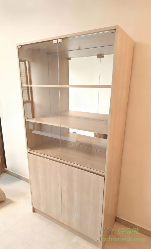 玻璃櫃內背板特別選用了鏡面設計，能夠反射光線，讓客廳看起來更加寬敞明亮。這對於香港的小戶型單位來說，是一個非常貼心的設計細節，既實用又能提升家居的空間感。