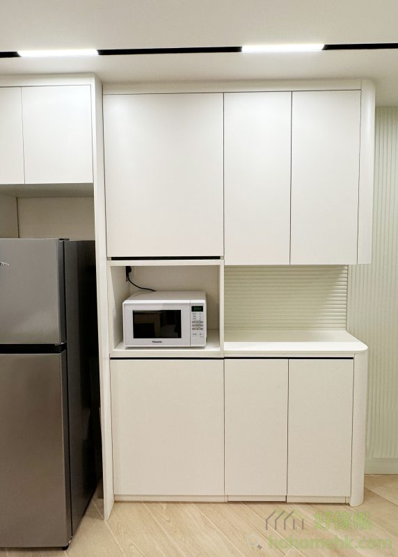 牆上一整排白色大櫃集餐邊櫃與儲物櫃於一身，簡約而實用，為小空間創造更多可能。