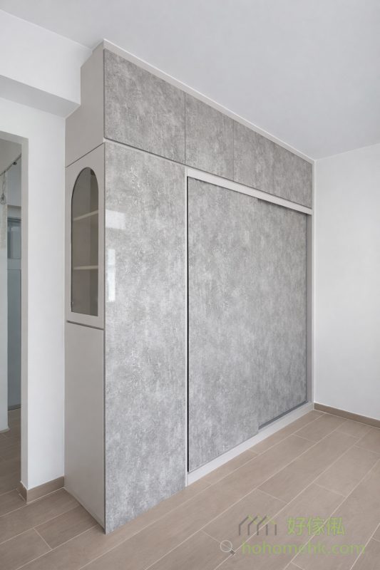 客廳以白色為主調，配搭少量玻璃櫃和深灰色地櫃，整體設計簡約而不失層次感。白色提升了空間感，而深灰和玻璃材質的點綴，則為空間增添了現代感，讓客廳成為全家人共享的舒適空間。