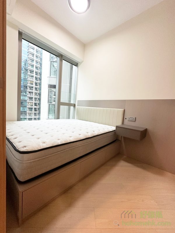 睡房的床頭板設計獨具匠心，直接延伸至整幅牆身，既保護了牆身避免日常使用的磨損，亦讓房間的整體風格更統一。簡約的線條與柔和的色調，營造出一個舒適又具設計感的私人空間。