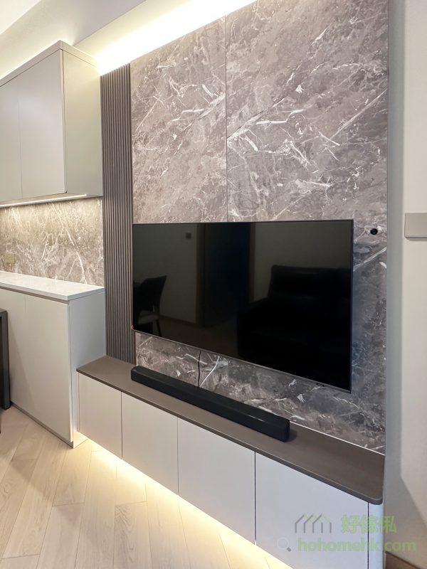 客廳電視地櫃懸空設計，不僅增加視覺上的輕盈感，還能有效利用底部空間作為清潔機械人的行走路線，方便打掃。同時，燈帶的應用讓櫃體周邊充滿層次感，為簡約的家居注入精緻細節。