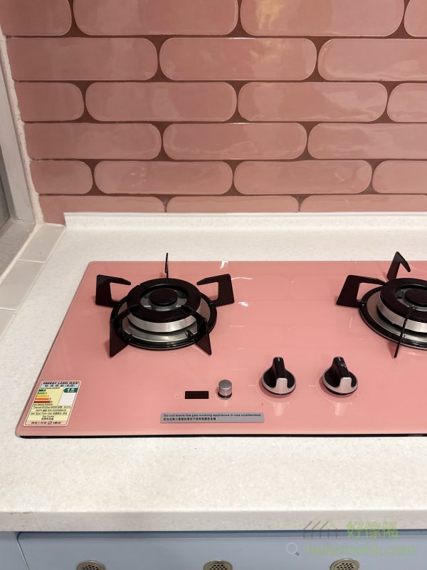 這個廚房設計以客戶的馬卡龍主題為靈感，採用天藍色焗漆作為地櫃和吊櫃的主色調，營造出充滿童話感的空間。每個細節都經過精心處理，所有收口條和櫃腳擋板都做到無色差，讓整體效果更加和諧美觀。再配上客戶精心挑選的粉紅色煮食爐，色彩碰撞之間呈現出獨特的視覺效果，令人耳目一新。