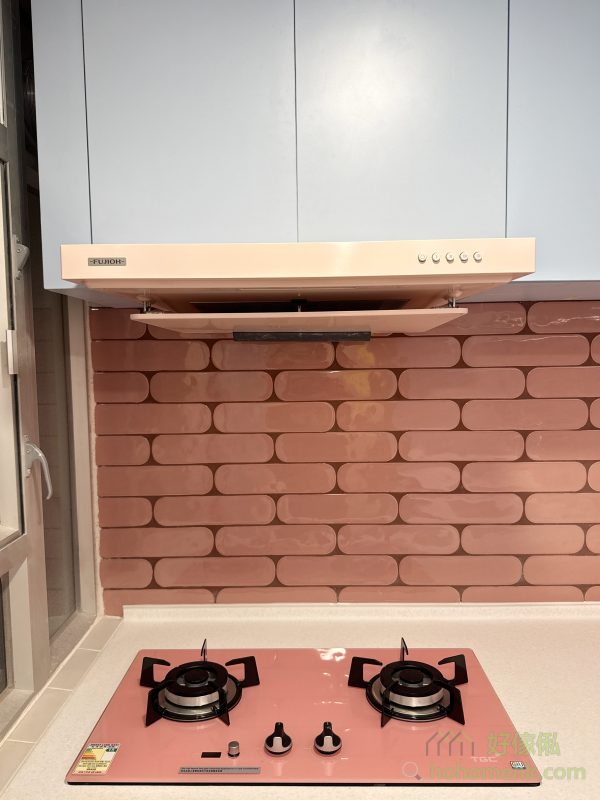 這個廚房設計以客戶的馬卡龍主題為靈感，採用天藍色焗漆作為地櫃和吊櫃的主色調，營造出充滿童話感的空間。每個細節都經過精心處理，所有收口條和櫃腳擋板都做到無色差，讓整體效果更加和諧美觀。再配上客戶精心挑選的粉紅色煮食爐，色彩碰撞之間呈現出獨特的視覺效果，令人耳目一新。