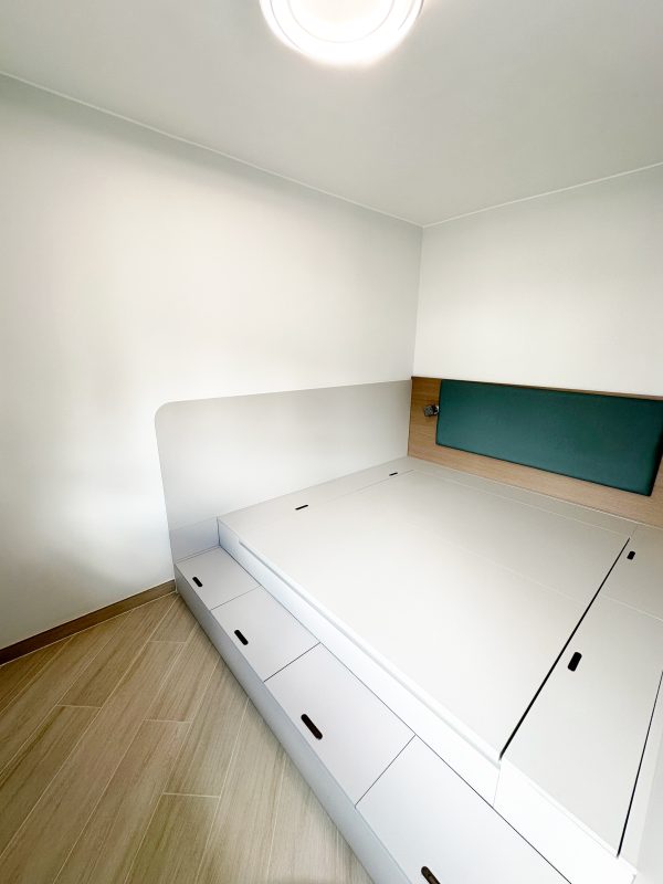 進入主人房，首先吸引目光的是大容量油壓床。床板下方擁有充裕的儲物空間，適合存放大型床品和季節性物品。而床頭的內嵌式設計，配合燈效，夜間使用更添溫馨。